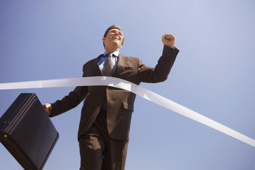 Businessman Crossing the Finish Line --- Image by © Royalty-Free/Corbis