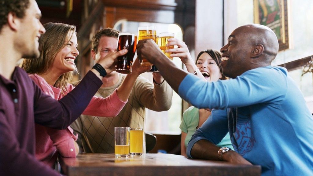 Varios-amigos-en-un-bar-brindando-con-cervezas-y-otras-bebidas