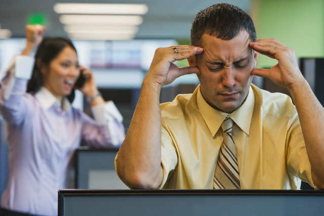 Businessman Irritated with Loud Coworker --- Image by © ColorBlind Images/Corbis