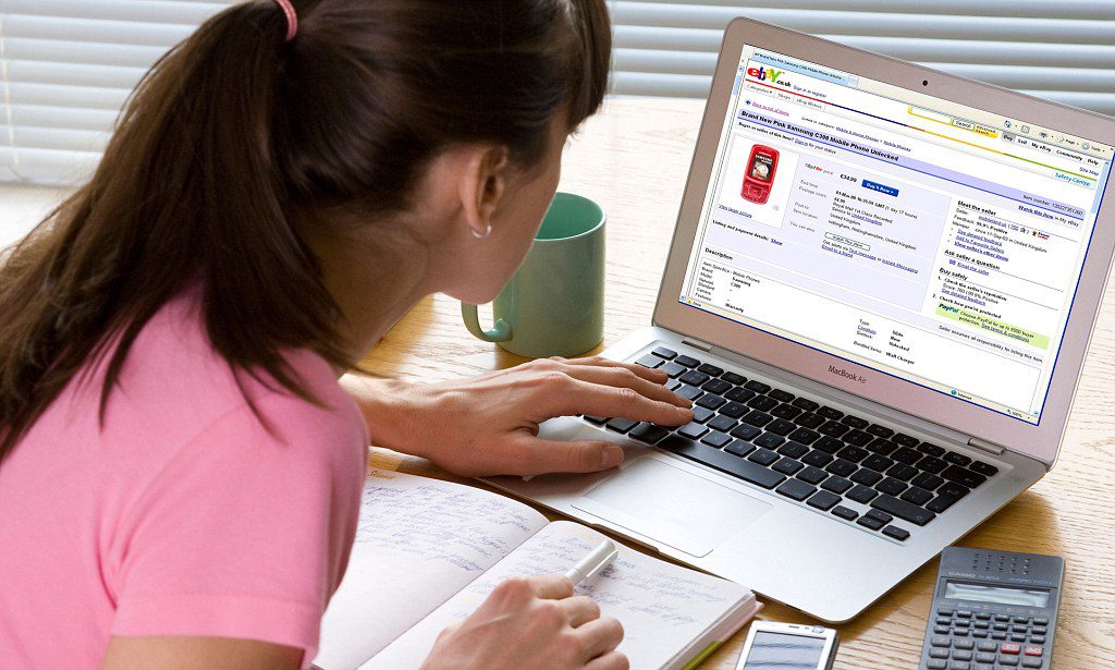 B85TT0 young woman looking at Ebay website on laptop computer. Image shot 2008. Exact date unknown.