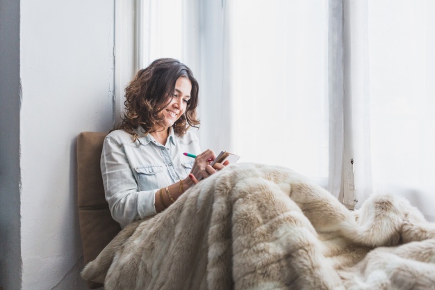 mujer-feliz-escribiendo-junto-a-la-ventana_23-2147601379